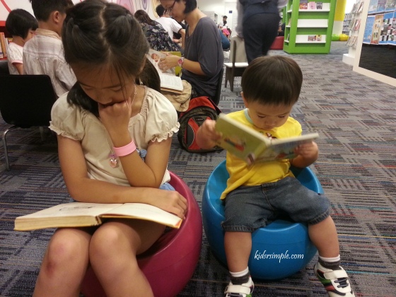 Reading with his sister in the library.
